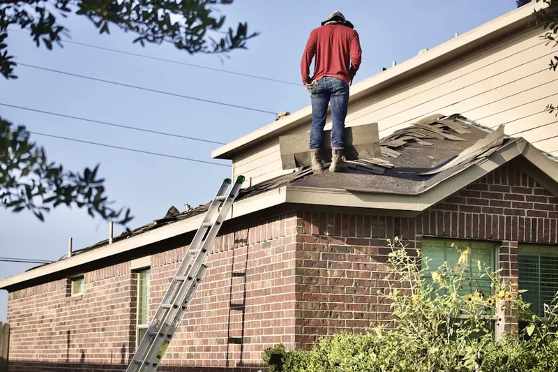 Professional roofer working on a residential roof in Greenwood and Hamilton